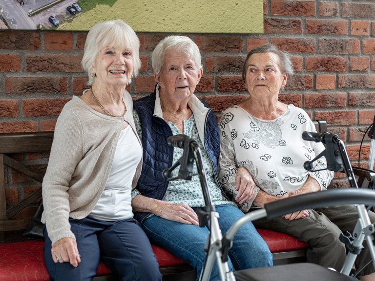 Drei Frauen schauen glücklich in die Kamera